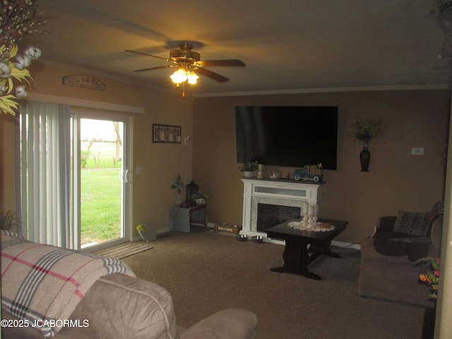 living area with a ceiling fan, ornamental molding, carpet flooring, a high end fireplace, and baseboards