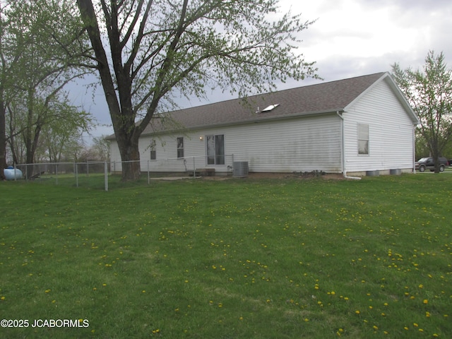 back of house featuring a yard, cooling unit, and fence
