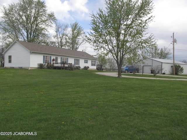 view of front facade with a deck, a front lawn, and a detached garage