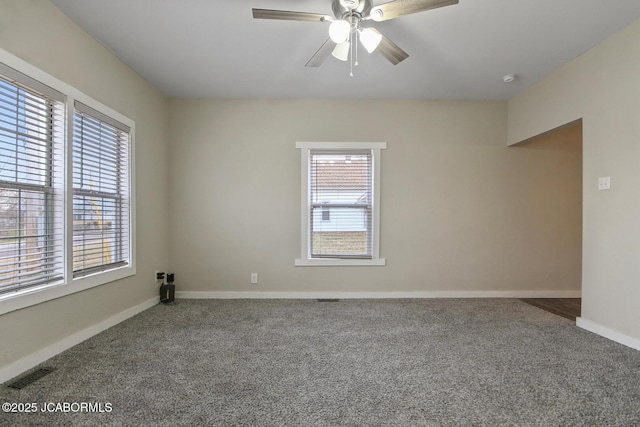 empty room featuring carpet, ceiling fan, and a wealth of natural light