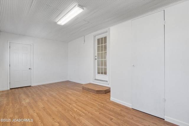 spare room featuring light wood-style flooring and baseboards