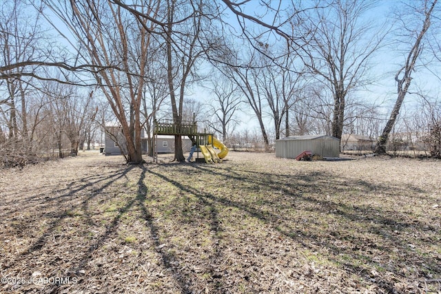 view of yard featuring a storage unit, an outdoor structure, and a playground