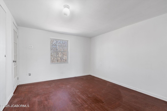 empty room featuring baseboards and wood finished floors