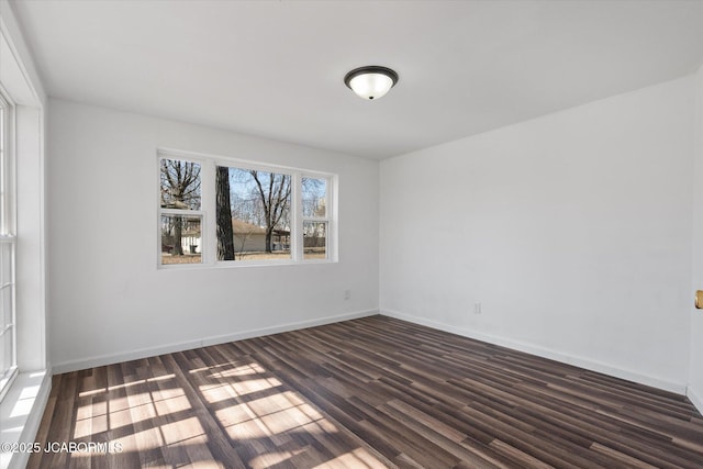 unfurnished room with dark wood finished floors and baseboards