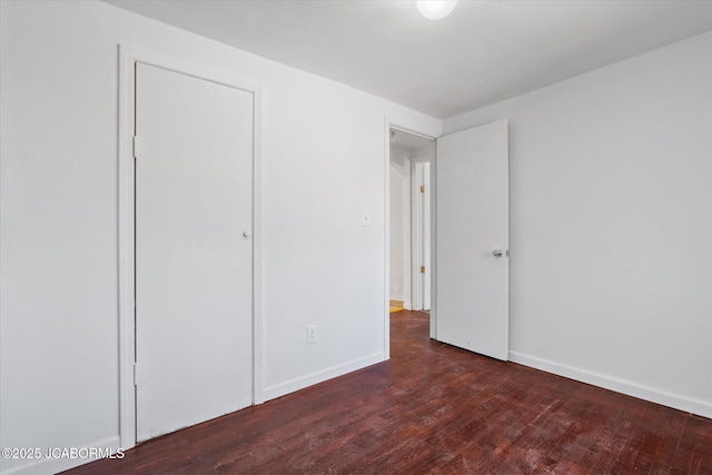 unfurnished bedroom with baseboards and hardwood / wood-style flooring