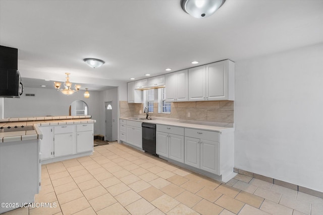 kitchen featuring an inviting chandelier, backsplash, white cabinetry, and black dishwasher