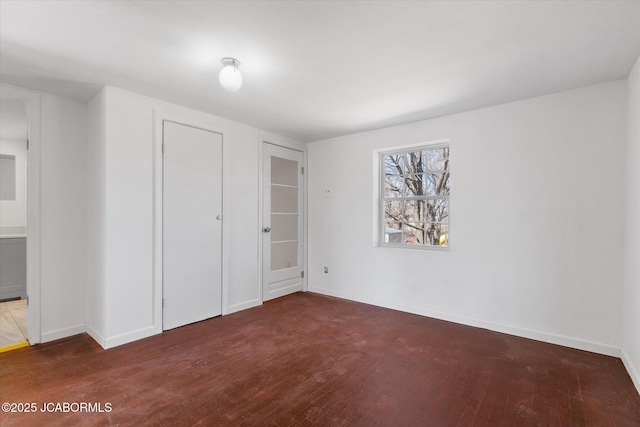 spare room featuring wood finished floors and baseboards