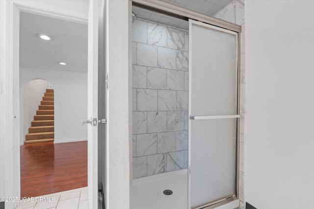 bathroom with recessed lighting, wood finished floors, a stall shower, and baseboards