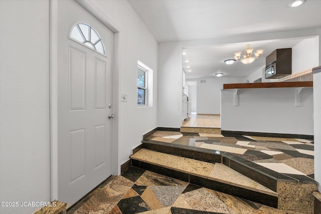 entryway featuring recessed lighting, baseboards, and a notable chandelier