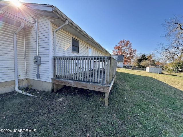 view of home's exterior with a deck and a lawn