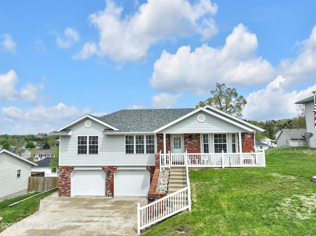 view of front of property with covered porch, driveway, a front yard, a garage, and brick siding