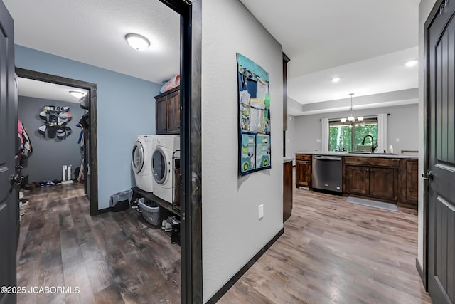 11169 Ridge Fork Dr, Holts Summit, MO 65043 - washroom with washing machine and clothes dryer, cabinet space, light wood-style floors, a chandelier, and recessed lighting