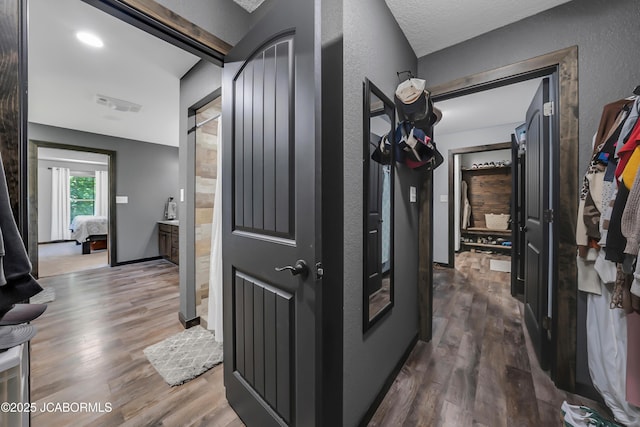 11169 Ridge Fork Dr, Holts Summit, MO 65043 - hallway with wood finished floors, a textured wall, and a barn door