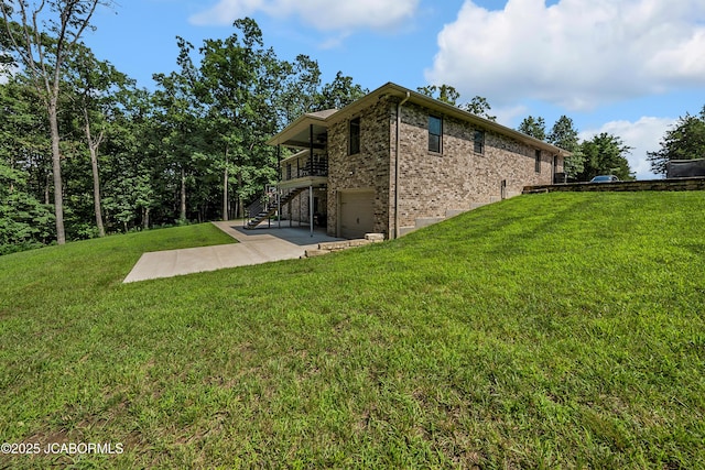 11169 Ridge Fork Dr, Holts Summit, MO 65043 - view of side of property with stairs, an attached garage, brick siding, a patio area, and a yard