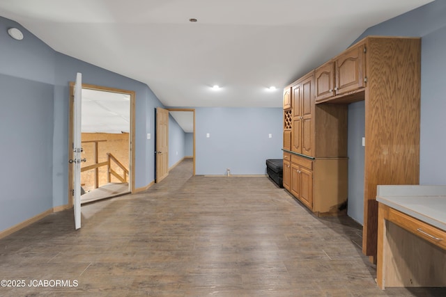 11169 Ridge Fork Dr, Holts Summit, MO 65043 - kitchen with vaulted ceiling, light wood-type flooring, light countertops, and brown cabinetry