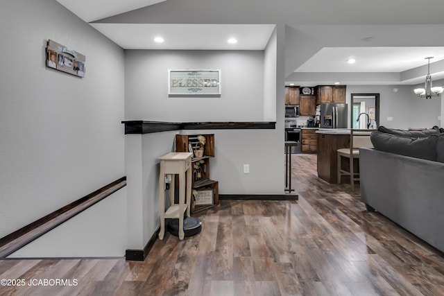 11169 Ridge Fork Dr, Holts Summit, MO 65043 - kitchen with stainless steel appliances, a breakfast bar, open floor plan, light countertops, and dark wood-style flooring