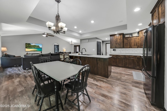 11169 Ridge Fork Dr, Holts Summit, MO 65043 - dining space featuring a ceiling fan, a raised ceiling, wood finished floors, a chandelier, and recessed lighting
