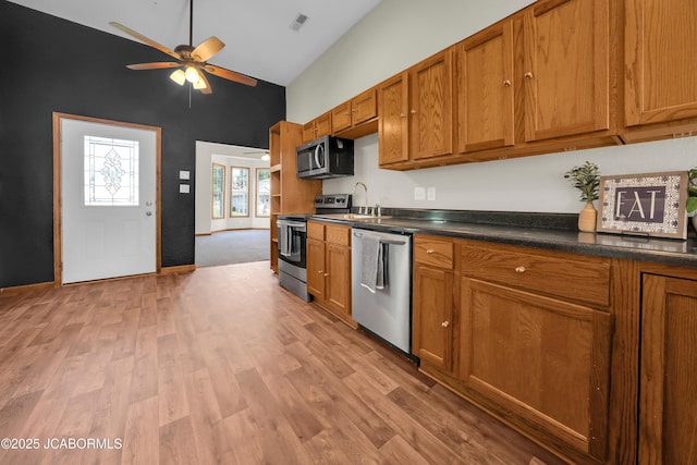 822 Center St, Fulton, MO 65251 - kitchen featuring stainless steel appliances, high vaulted ceiling, brown cabinets, ceiling fan, and dark countertops