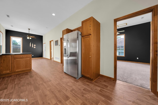 822 Center St, Fulton, MO 65251 - kitchen featuring stainless steel fridge, brown cabinets, ceiling fan, light wood finished floors, and plenty of natural light