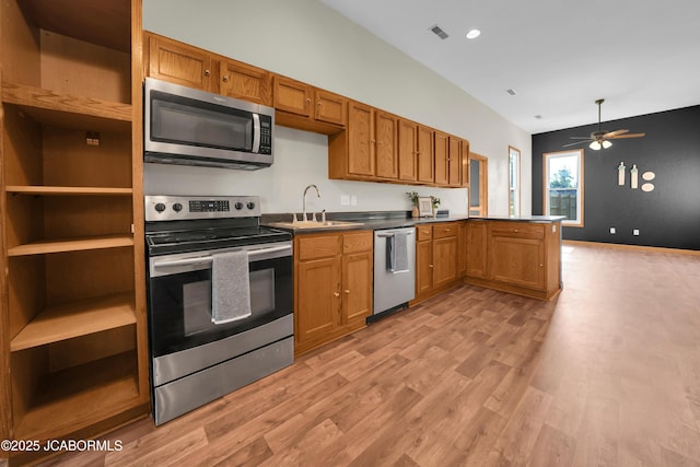 822 Center St, Fulton, MO 65251 - kitchen with stainless steel appliances, a peninsula, light wood-style floors, ceiling fan, and brown cabinets