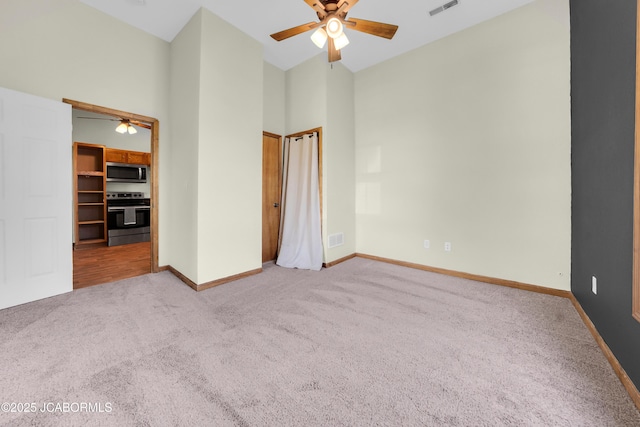 822 Center St, Fulton, MO 65251 - unfurnished bedroom featuring carpet floors, a towering ceiling, a spacious closet, and a ceiling fan