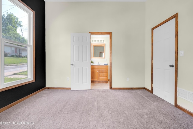 822 Center St, Fulton, MO 65251 - unfurnished bedroom with light colored carpet, multiple windows, and ensuite bath
