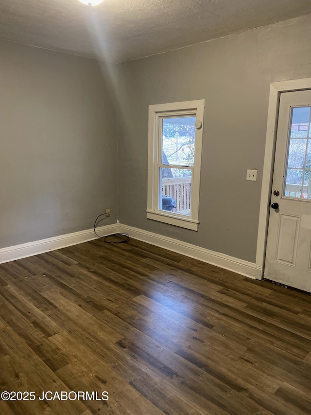 entryway featuring dark wood-type flooring, a wealth of natural light, and a textured ceiling