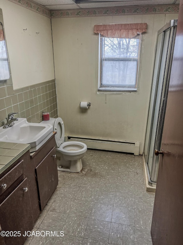 full bathroom featuring tasteful backsplash, a baseboard radiator, toilet, a shower stall, and vanity