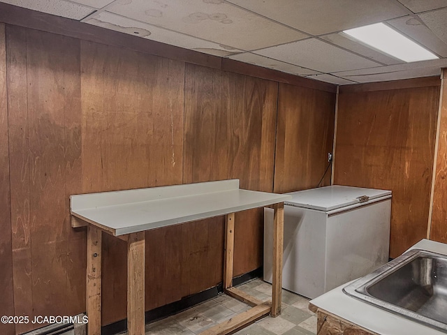 laundry room with light floors, a sink, and wooden walls