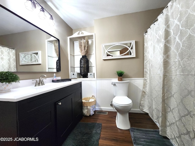 bathroom featuring toilet, vanity, wood finished floors, and visible vents