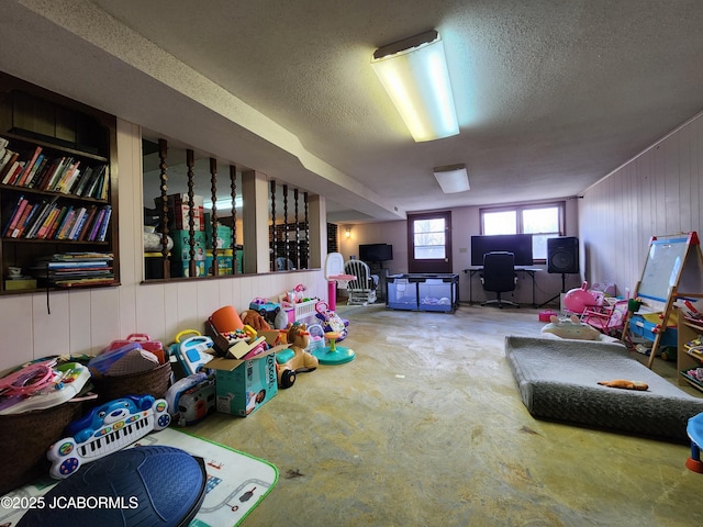 game room with unfinished concrete floors and a textured ceiling