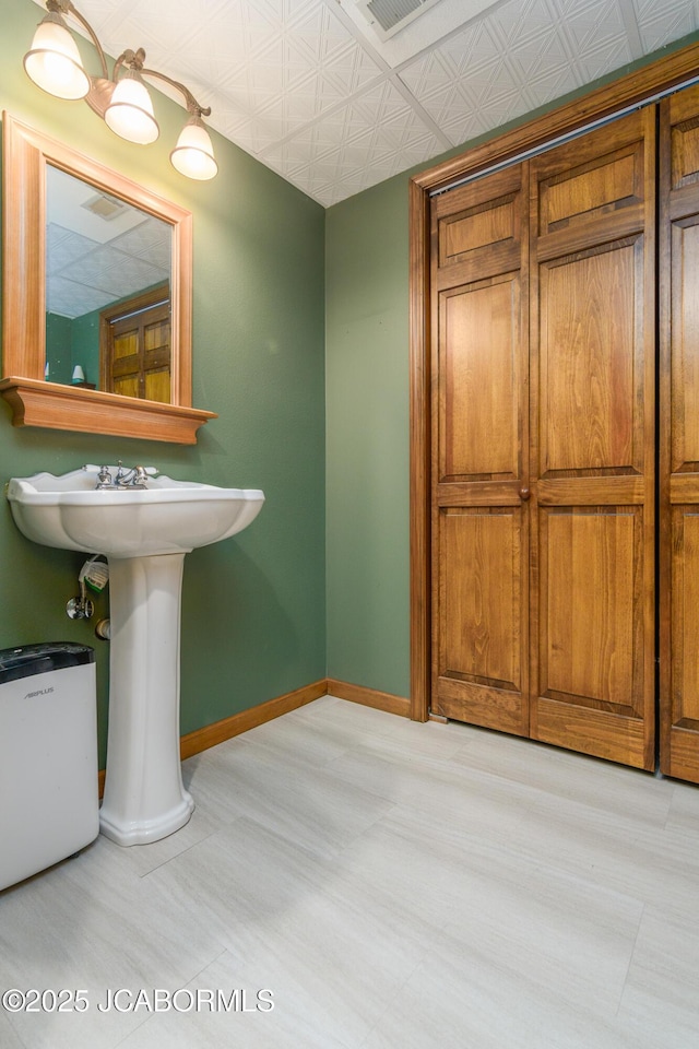 bathroom featuring an ornate ceiling, visible vents, and baseboards