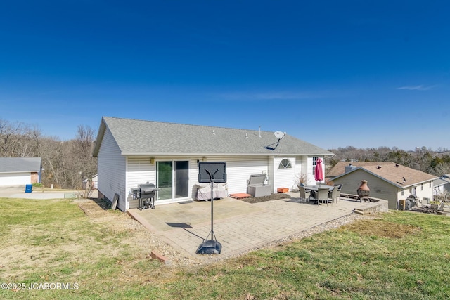 back of house with a patio, a shingled roof, and a lawn