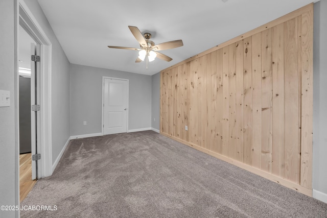 53036 Bird Haven Rd, Centertown, MO 65023 - unfurnished bedroom with carpet floors, wood walls, and a ceiling fan