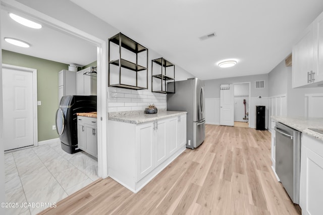 53036 Bird Haven Rd, Centertown, MO 65023 - kitchen featuring appliances with stainless steel finishes, washer / clothes dryer, backsplash, and white cabinets