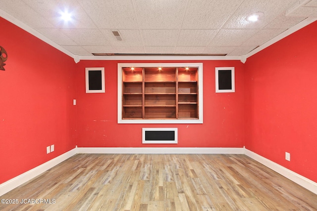 907 Primrose Ln, Jefferson City, MO 65109 - empty room with built in shelves, crown molding, and wood finished floors