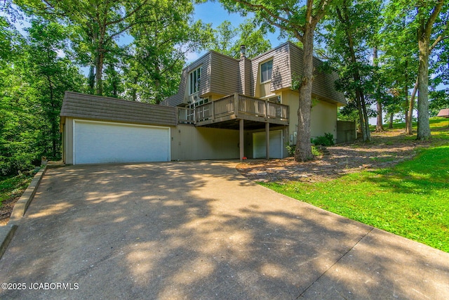 907 Primrose Ln, Jefferson City, MO 65109 - view of front facade with mansard roof, a wooden deck, driveway, and stucco siding