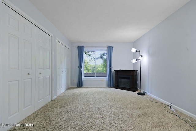 907 Primrose Ln, Jefferson City, MO 65109 - unfurnished living room featuring carpet flooring and a glass covered fireplace