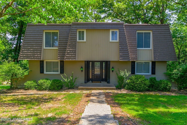 907 Primrose Ln, Jefferson City, MO 65109 - view of front of home with mansard roof, brick siding, and a front lawn