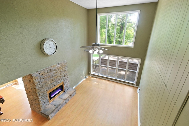 907 Primrose Ln, Jefferson City, MO 65109 - unfurnished living room with wood finished floors, a fireplace, a textured wall, and ceiling fan