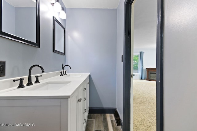 907 Primrose Ln, Jefferson City, MO 65109 - bathroom featuring double vanity and wood finished floors