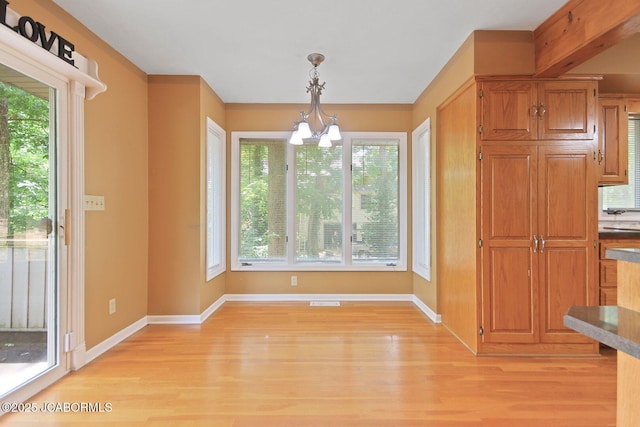 907 Primrose Ln, Jefferson City, MO 65109 - unfurnished dining area featuring a chandelier, light wood finished floors, and healthy amount of natural light