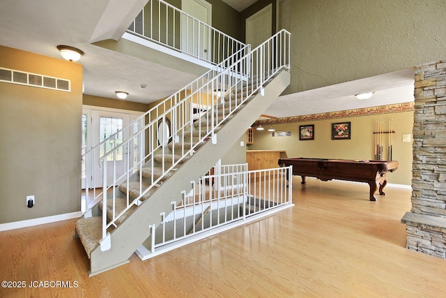 907 Primrose Ln, Jefferson City, MO 65109 - staircase featuring wood finished floors, pool table, and a towering ceiling
