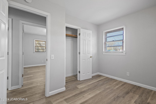 unfurnished bedroom with a closet and light hardwood / wood-style flooring