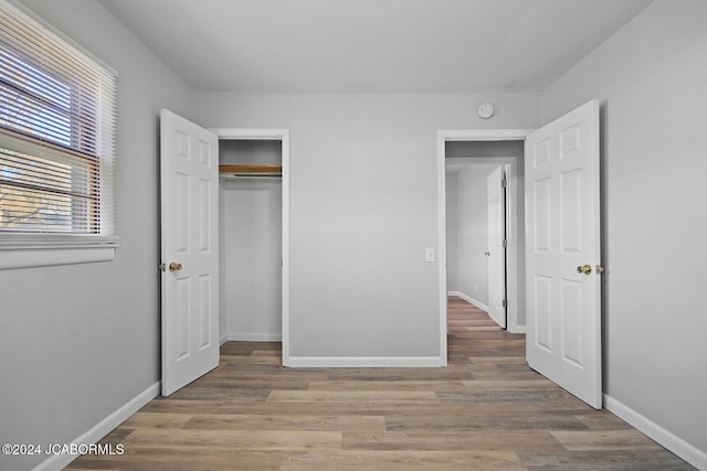 unfurnished bedroom with light hardwood / wood-style floors and a closet