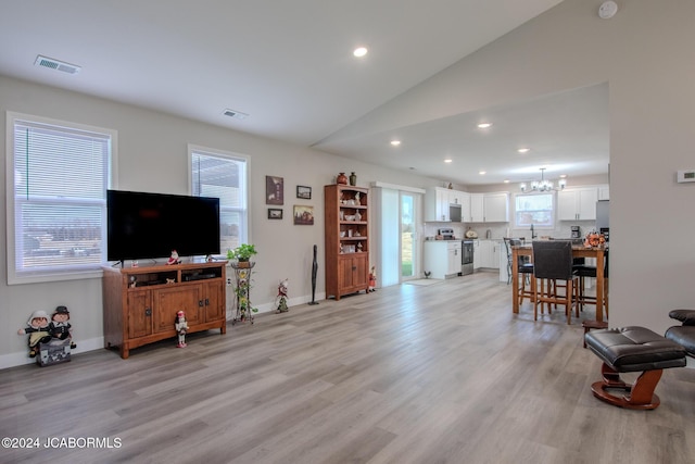 living room with light hardwood / wood-style flooring and lofted ceiling