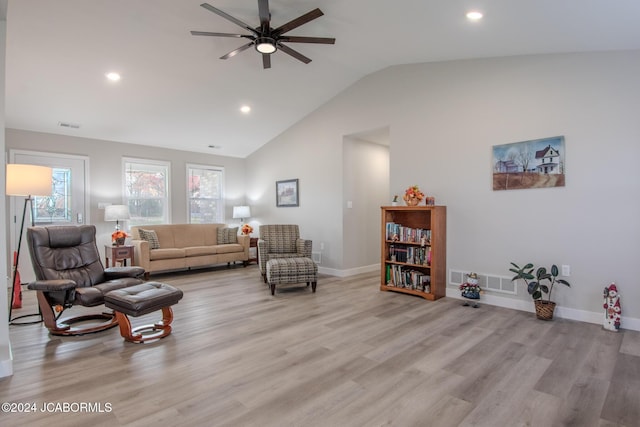 living room with light wood-type flooring, vaulted ceiling, and ceiling fan