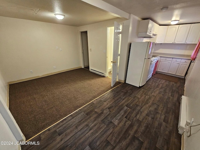 kitchen with white fridge, white cabinetry, baseboard heating, and dark carpet