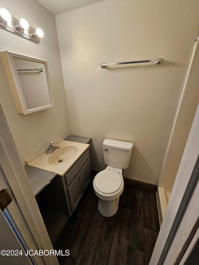 bathroom with hardwood / wood-style floors, vanity, and toilet