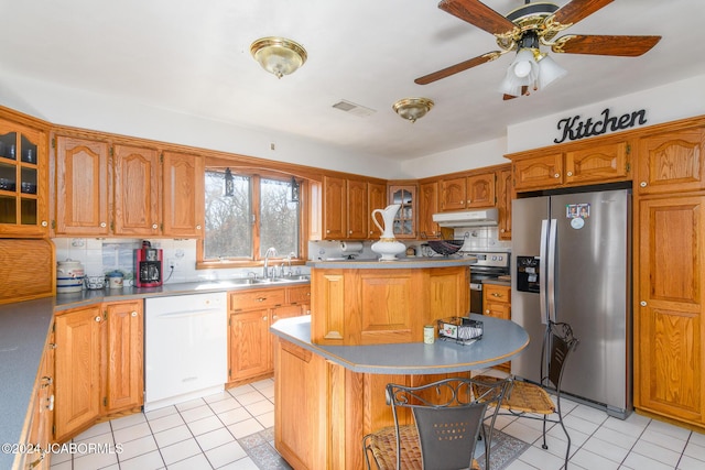 kitchen with ceiling fan, sink, stainless steel appliances, tasteful backsplash, and a kitchen island